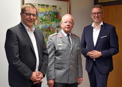 Landrat Ingo Brohl (r.) und Vorstandsmitglied Dr. Lars Rentmeister (l.) verabschieden Kreisverbindungskommando-Leiter Michael Herbrecht (m.) in seinen Ruhestand.